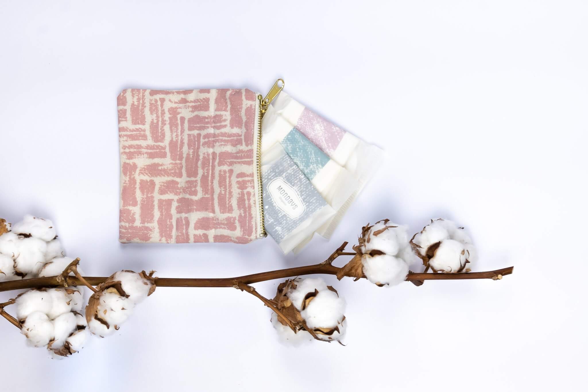 Organic Mondays eco friendly female hygiene products pictured against a white backdrop with a branch of cotton.